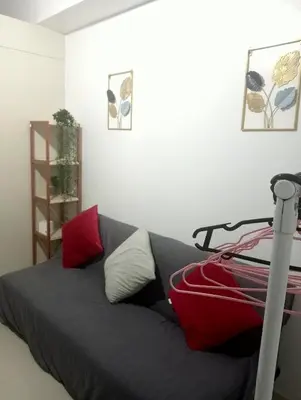 a bedroom with a gray bed with red and white pillows at Sea Residences Tower EF Rose in Manila