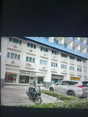 a motorcycle parked in front of a large building at Sea Residences Tower EF Rose in Manila