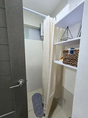 a bathroom with a shower with a shower curtain at Cozy Nature-Inspired Studio Unit in Cubao in Manila