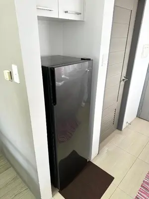 a small kitchen with a refrigerator in a room at Cozy Nature-Inspired Studio Unit in Cubao in Manila
