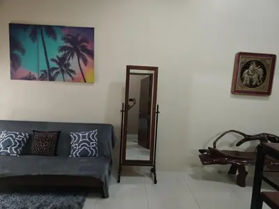 a living room with a couch and a mirror at Cozy Condo Across NAIA T3 One Palm Tree in Manila
