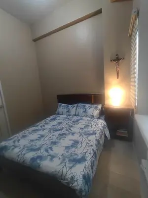 a bedroom with a bed with a blue comforter at Cozy Condo Across NAIA T3 One Palm Tree in Manila