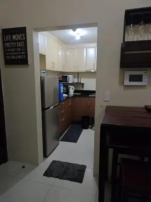 a kitchen with a refrigerator and a counter top at Cozy Condo Across NAIA T3 One Palm Tree in Manila