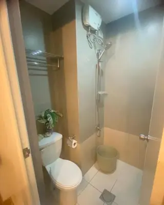 a small bathroom with a toilet and a shower at Azure Haven in Manila