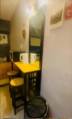 a kitchen with a yellow counter and stools in a room at Azure Haven in Manila
