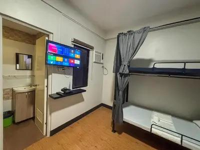 a room with two bunk beds and a flat screen tv at The Budget Inn in Manila