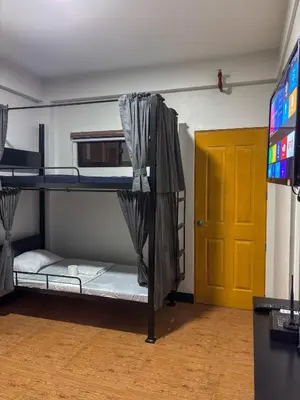 a room with two bunk beds and a television at The Budget Inn in Manila