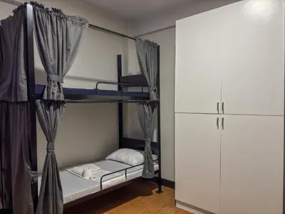 a bedroom with two bunk beds and a refrigerator at The Budget Inn in Manila