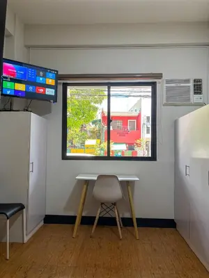 a table and a chair in a room with a window at The Budget Inn in Manila