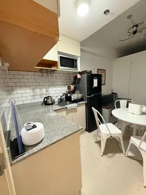 a kitchen with a counter and a table and a refrigerator at LA Nook in Manila