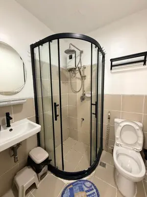 a bathroom with a shower and a toilet and a sink at LA Nook in Manila