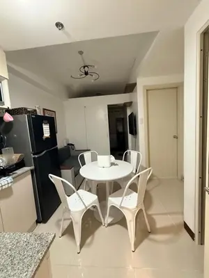 a kitchen with a white table and chairs in a room at LA Nook in Manila