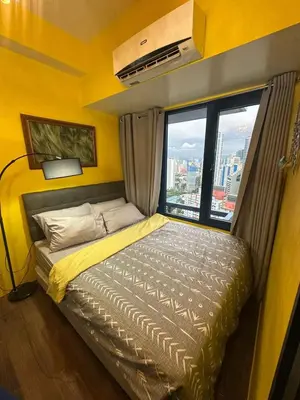 a small bed in a room with a window at Sunbeam - Lush Residence in Manila