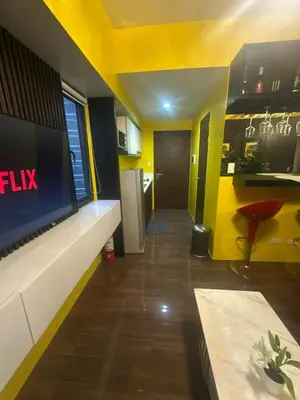 a room with a yellow ceiling and a living room at Sunbeam - Lush Residence in Manila