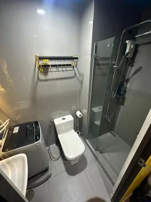 a bathroom with a toilet and a glass shower at Sunbeam - Air Residence 45th floor in Manila