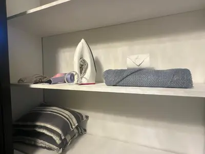 a shelf with a sink and a mirror and a towel at Sunbeam - Air Residence 45th floor in Manila