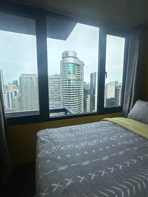 a bedroom with a view of a city from a window at Sunbeam - Air Residence 45th floor in Manila