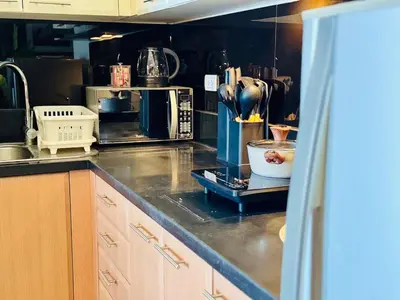 a kitchen with a counter top with a counter top at Cozy unit with balcony Netflix walk to Venice Mall in Manila