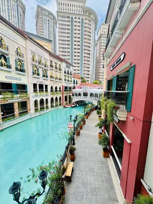 a swimming pool in a city with tall buildings at Cozy unit with balcony Netflix walk to Venice Mall in Manila