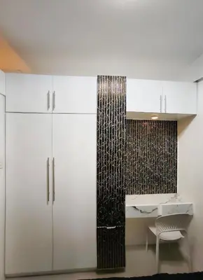 a kitchen with white cabinets and a table and a chair at La Casa Victoria-Near Moa and NAIA in Manila