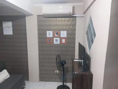 a room with a television and a wall with pictures at Affordable Townhouse Imus cavite greenpark villas 2 in Imus