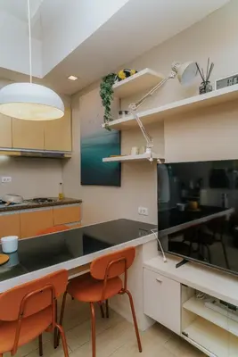 a kitchen with a black counter and orange chairs at Chic Eastwood City Studio w Pool and Gym Access in Manila