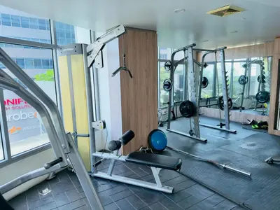 a gym with treadmills and weights in a building at Chic Eastwood City Studio w Pool and Gym Access in Manila