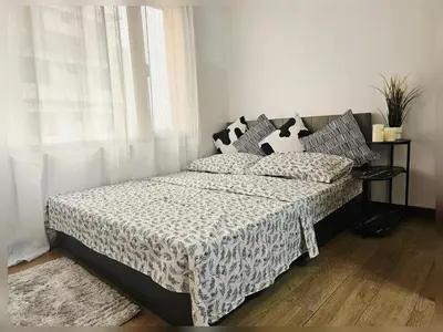 a bedroom with a bed with black and white sheets and a window at Paseo Verde Condo Unit in Las Pinas - Sleeps 2 Adults & 2 Children in Manila