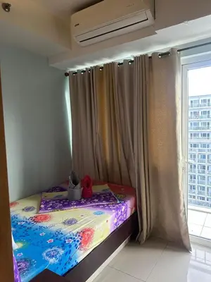 a small bed in a room with a window at Shell Residences Moa AJ in Manila