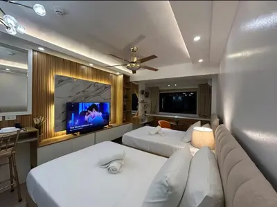 a living room with two beds and a tv at Casa Navarro - Estrella in Manila