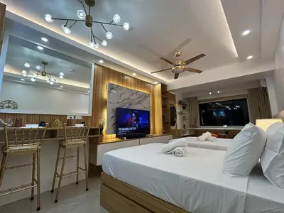 a bedroom with a bed and a bar with a tv at Casa Navarro - Estrella in Manila