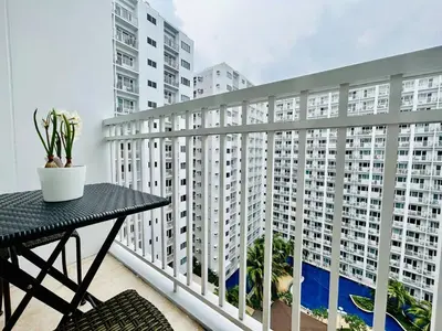 a balcony with a table and some white buildings at Affordable Condotel Stay in Pasay, MOA Complex in Sampong