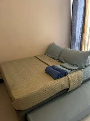 a bed with two pillows and two towels on it at Cozy Studio Viceroy Residences in Manila