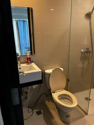 a bathroom with a toilet and a sink and a shower at Cozy Studio Viceroy Residences in Manila