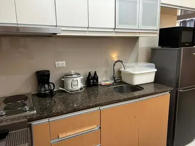 a small kitchen with a sink and a refrigerator at Cozy Studio Viceroy Residences in Manila