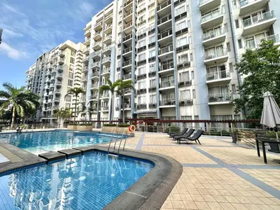 a swimming pool in front of a large apartment building at One Palm Tree Villas at Newport, Near NAIA T3 in Manila