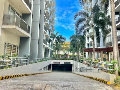 a walkway between two buildings with palm trees at One Palm Tree Villas at Newport, Near NAIA T3 in Manila