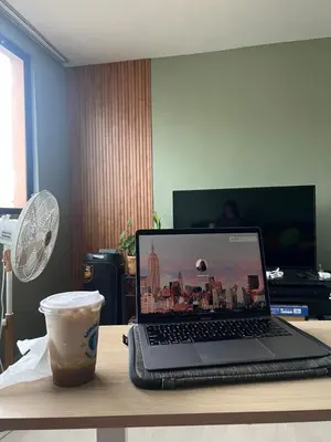 a laptop computer sitting on a desk with a cup of coffee at Jopays 2BR, Brand New Unit in Cainta