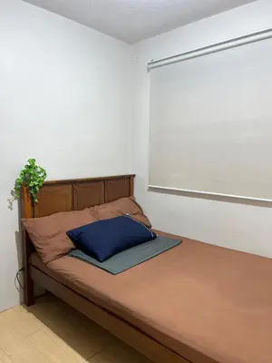 a bed in a white room with a window at Cozy 2BR at an Italian inspired condo near Ortigas in Manila