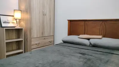 a bedroom with a large bed with a wooden headboard at Cozy 2BR at an Italian inspired condo near Ortigas in Manila