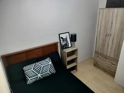a bedroom with a bed with a pillow and a cabinet at Cozy 2BR at an Italian inspired condo near Ortigas in Manila
