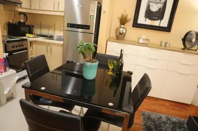 a kitchen with a table with chairs and a refrigerator at The Mosaic Tower in Manila