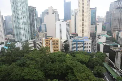 a city skyline with tall buildings and trees at The Mosaic Tower in Manila
