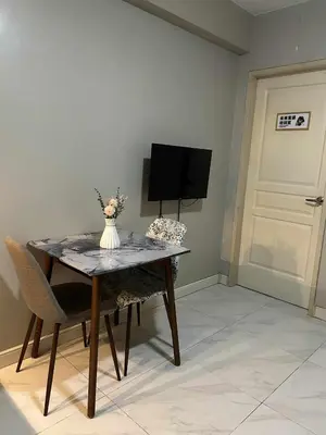a dining room table with a vase of flowers on it at Condo near MOA Monarch in Manila