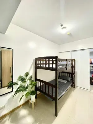 a bedroom with bunk beds and a potted plant at AzurestaycationbyGS in Manila