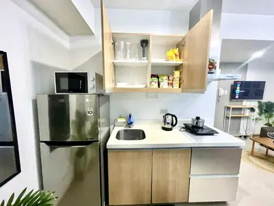 a small kitchen with a refrigerator and a sink at AzurestaycationbyGS in Manila