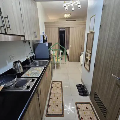a kitchen with a sink and a counter top at 1BR Pool View Balcony Near MOA Shore 2 Tower 1 in Manila