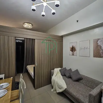 a living room with a bed and a dining table at 1BR Pool View Balcony Near MOA Shore 2 Tower 1 in Manila