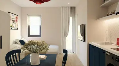 a kitchen with a table with a vase of flowers on it at Llanes A Studio Apartment in Manila