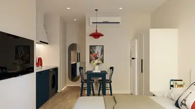 a bedroom with a bed and a table with chairs at Llanes A Studio Apartment in Manila